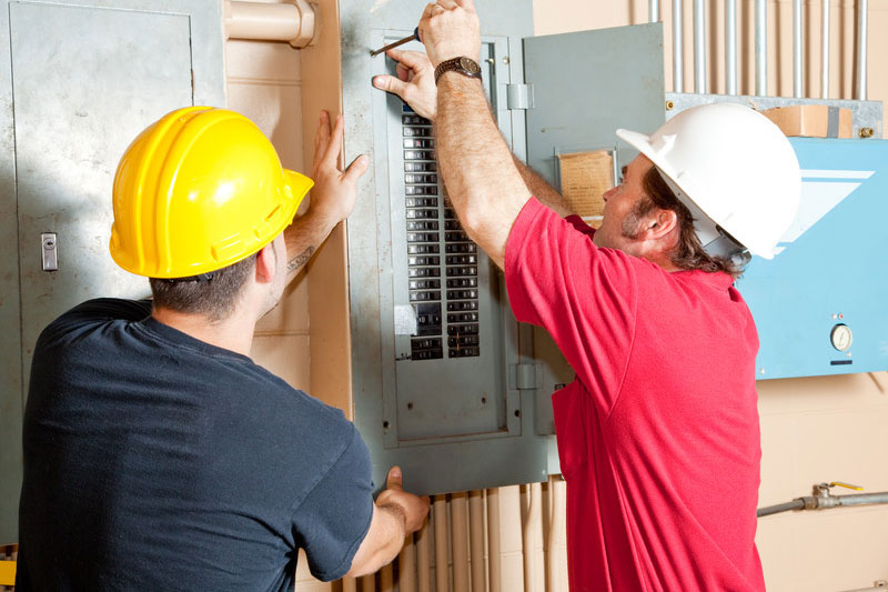 Electricians working on an electrical panel in West Texas.